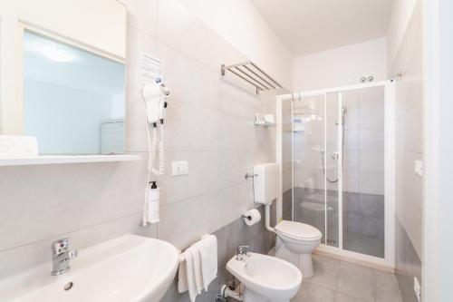 a white bathroom with a toilet and a sink at Hotel Anny in Lido di Jesolo