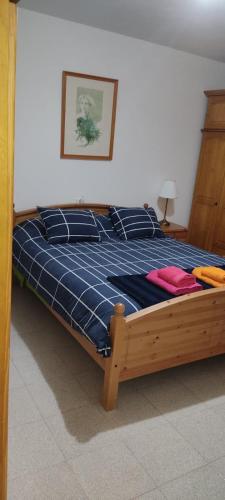 a bedroom with a bed with a blue plaid blanket at El Pajar casa campestre in El Pinar del Hierro