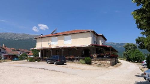 a house with a car parked in front of it at Hotel Riva in Stenje