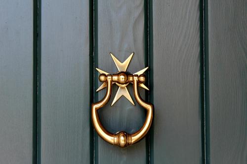a bronze door knocker on a wooden door at Balzanija Boutique Accommodation in Balzan