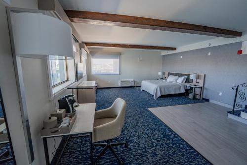 a bedroom with a bed and a desk with a chair at Seaport Resort and Marina in Fairhaven
