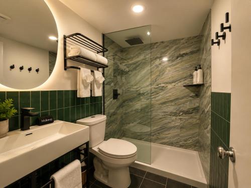 a bathroom with a toilet and a sink and a shower at The Wesley Boutique Hotel Page, AZ in Page