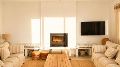 a living room with a couch and a fireplace at Villa Guvalmar Chalet Roche in Roche