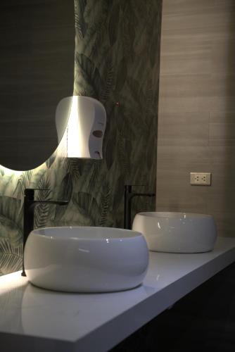 a bathroom with two sinks on a counter with a light at Hotel INTERnazionale in Ayacucho