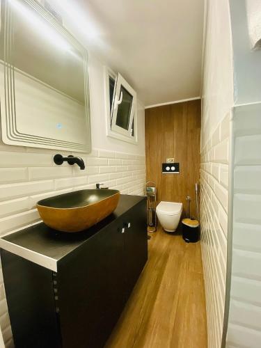 a bathroom with a wooden bowl sink on a black counter at Phoenix Garden Apartments - 4 - in Athens