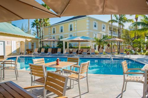 a patio with a table and chairs next to a pool at Sunshine Suites Resort in George Town