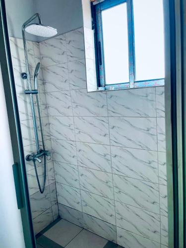 a bathroom with a shower with a glass door at Renova-Immo in Yaoundé