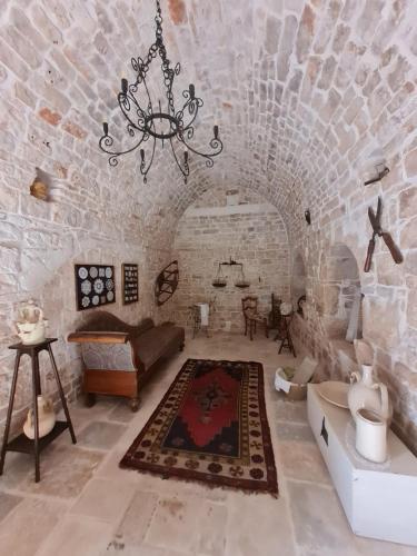 ein Wohnzimmer mit einer Backsteinwand und einem Kronleuchter in der Unterkunft Villa Morea-Relax in piscina in Putignano
