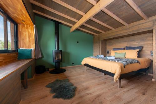a bedroom with a bed in a room with green walls at LES 2 CABANES in Labastide-Gabausse