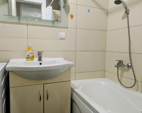 ein Badezimmer mit Waschbecken und Dusche in der Unterkunft Nirvana Apartman in Brčko