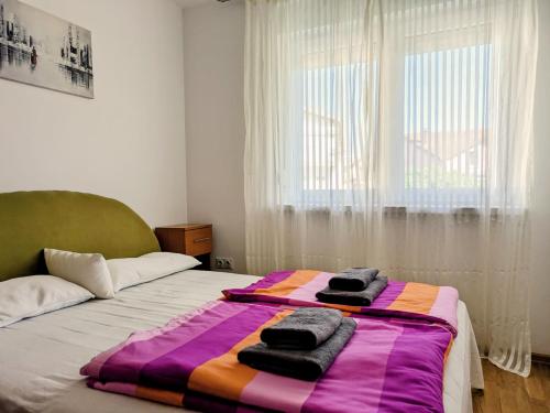 ein Schlafzimmer mit einem Bett, auf dem Handtücher liegen in der Unterkunft Nirvana Apartman in Brčko