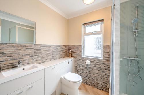 a bathroom with a toilet and a sink and a shower at 3 Bed in Seaton oc-mbdal in Seaton