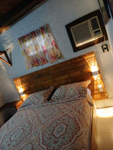 a bedroom with a bed with a wooden headboard and lights at Toucherit Standar triple in La Asunción