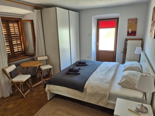 a bedroom with a large bed and a table and chairs at Apartmant Ivan in Malinska