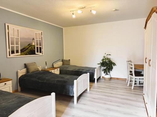 two beds in a room with a table and chairs at Ferienhof-Wohler-Wohnung-5 in Bojendorf