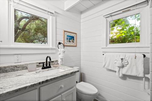 a white bathroom with a toilet and a sink at Margarita Days in Seagrove Beach