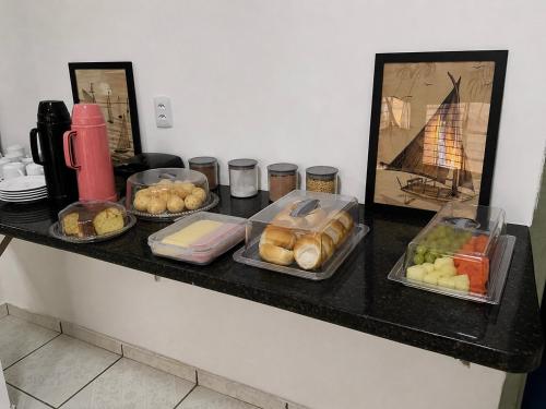 a black counter with different types of food on it at HOTEL ITAPUÃ vg in Várzea Grande