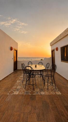 a dining room with a table and chairs and the ocean at Thayri Hostel - Sea View in Sidi Kaouki