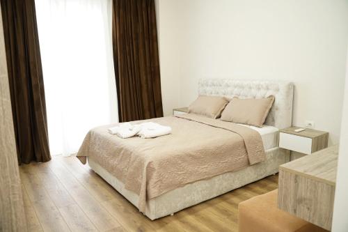 a bedroom with a bed with two towels on it at Corner Apartments in Tirana