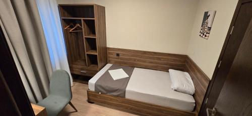 a small bedroom with a bed and a chair at Drei Schweizer Hotel in Neuwied