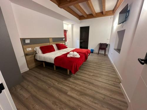 ein Schlafzimmer mit einem Bett mit rot-weißer Bettwäsche in der Unterkunft Casa Cando in Castroverde