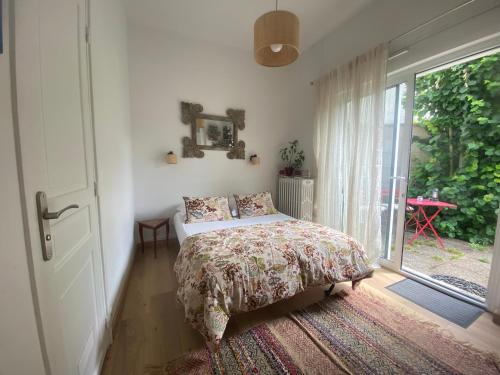 a bedroom with a bed and a large window at Les Charmettes chambre double indépendante in Villemoisson-sur-Orge