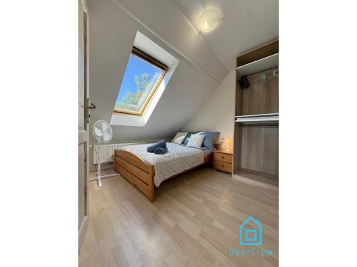 a bedroom with a bed and a window at NaWypasie Grand Apartment with Fireplace Beautiful Garden SUP Board and Just 30 Minutes from Gdańsk and Gdynia in Szemud