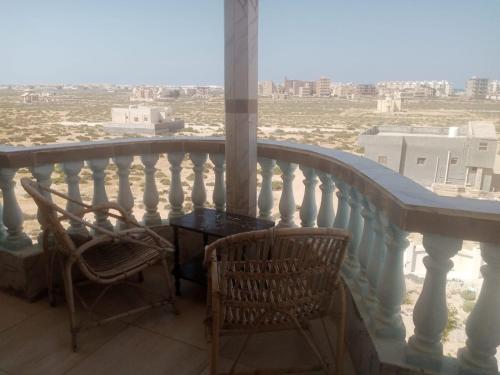 a balcony with two chairs and a table at Zaytouna camp Room 2 in Marsa Matruh