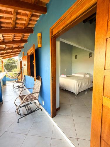 a bedroom with a bed and two chairs on a patio at Casa Magna in Itacaré