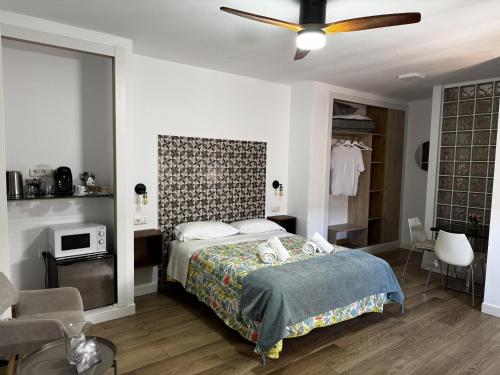 a bedroom with a bed and a ceiling fan at Patio de Los Barberos 3 in Valle de Abdalagís