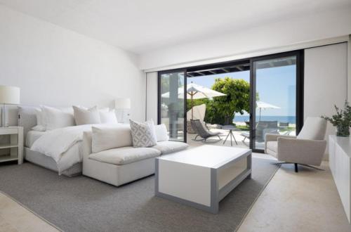 a white living room with a couch and a table at Porta Fortuna Villa Punta Mita Gates in Punta Mita