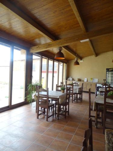 a dining room with tables and chairs and windows at Hotel Rural Sol 7 in Piedrahita de Castro