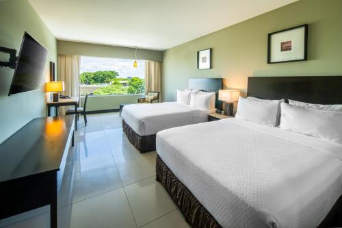a hotel room with two beds and a balcony at Crowne Plaza Villahermosa by IHG in Villahermosa