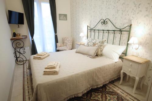 a bedroom with a large white bed with a chair at Sinfonia Barocca in Modica