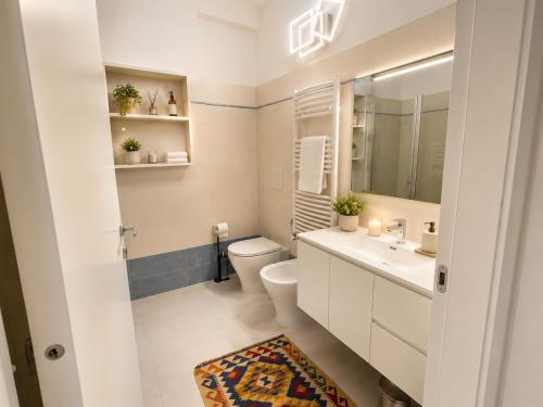 a bathroom with a toilet and a sink and a mirror at Sunrise Apartment by Symphonya Luxury Holiday Rentals in Otranto
