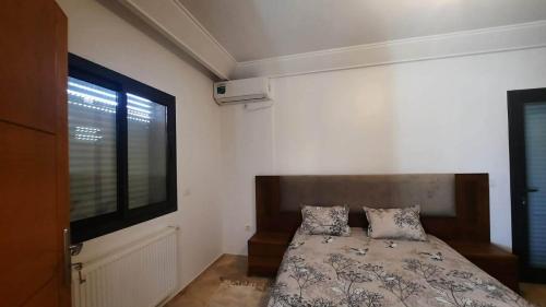 a bedroom with a bed and a large window at Fantastic appartement in Hammam Sousse