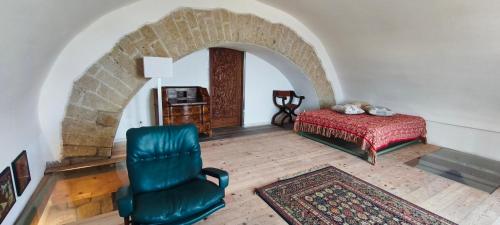 a bedroom with a bed and a chair in a room at Guesthouse Acherusia in Bacoli