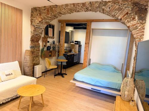 a bedroom with a bed and a living room at Studio LA PETITE PAUSE in Ajaccio