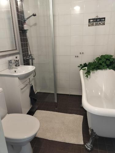 a bathroom with a toilet and a sink and a tub at Gran Palmu in Pori