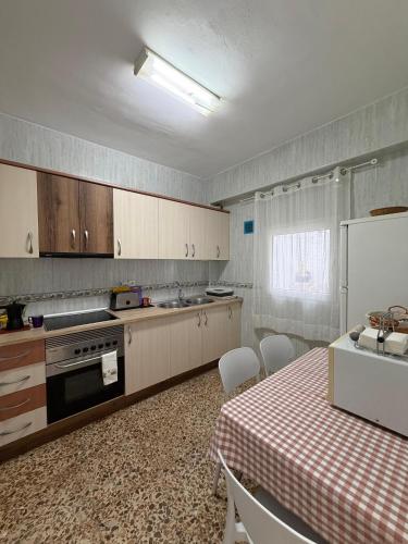 a kitchen with a table and a refrigerator and a table and chairs at Hospederia Ortiz 2 in Níjar