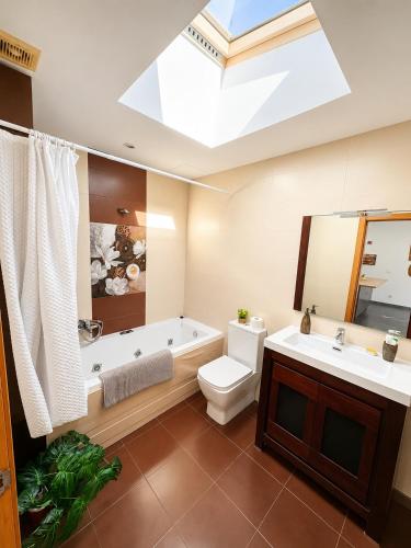 a bathroom with a tub and a toilet and a sink at Apartamento As Caldelas in O Grove