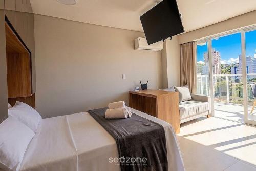 a bedroom with a bed and a television and a couch at Modern studio in a condominium with pool MSU0701 in Governador Valadares