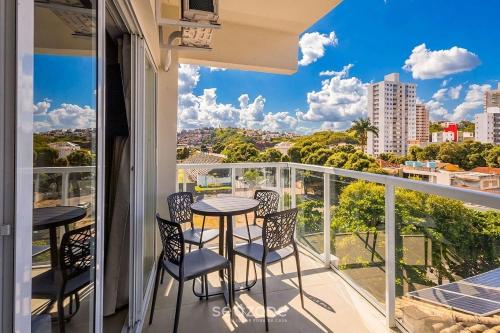 a balcony with two tables and chairs and a view of the city at Studio in a cond. w/gym in the city center MSU0301 in Governador Valadares