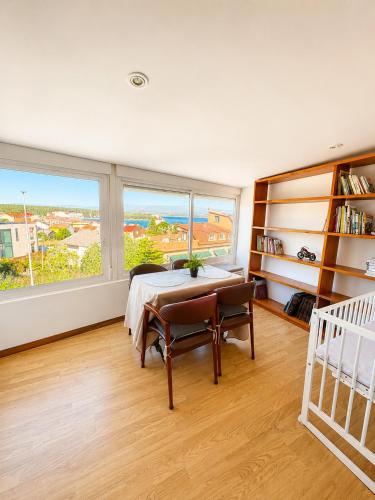 a bedroom with a table and a large window at Apartamento As Caldelas in O Grove