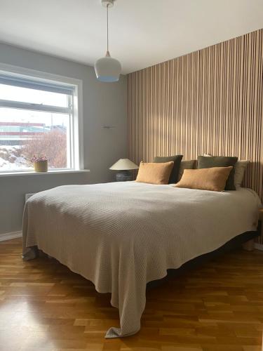 a bedroom with a large bed and a window at G6 Apartment in Grundarfjordur