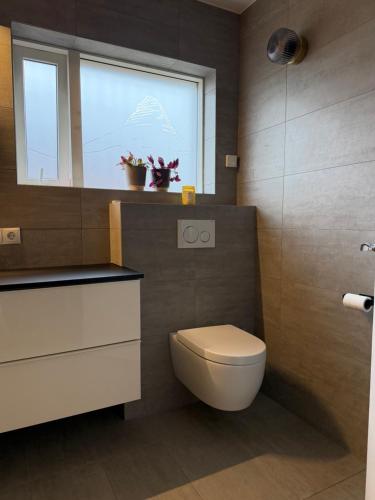 a bathroom with a toilet and a window at G6 Apartment in Grundarfjordur