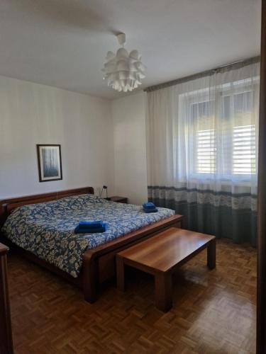 a bedroom with a bed and a table and a window at Lakeview apartment in Pergine Valsugana