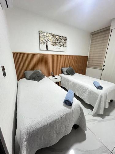 ein Zimmer mit zwei Betten, auf denen Handtücher liegen in der Unterkunft Torres del Mar in Manzanillo