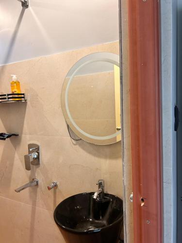 a bathroom with a black sink and a mirror at Rodali stay in Dibrugarh