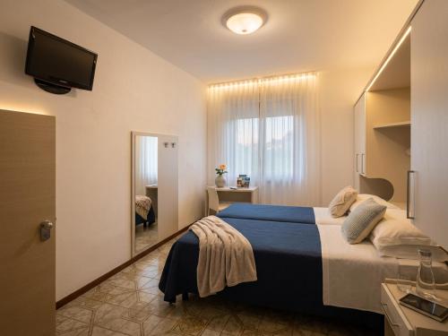 a bedroom with a large bed and a mirror at B&B - Meuble' - Hotel " CORDIALE " in Misano Adriatico